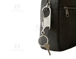 Chaveiro de metal com design de handcuff em close-up, incluindo anel e corrente, indicando segurança e controle.