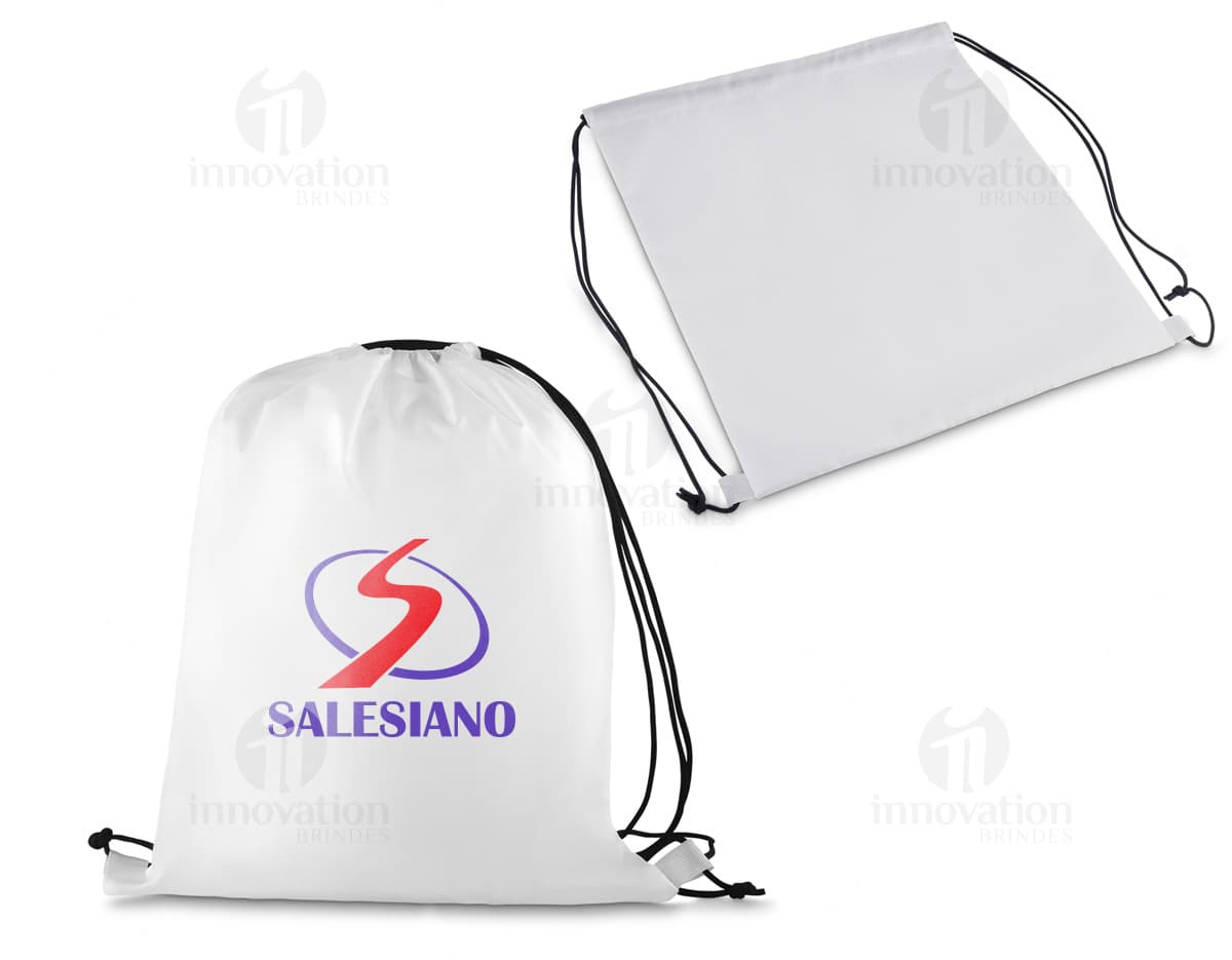 Sacola mochila nylon 210gr sobre um fundo branco, com um notebook, torradeira, papel em branco e outros objetos de cozinha e