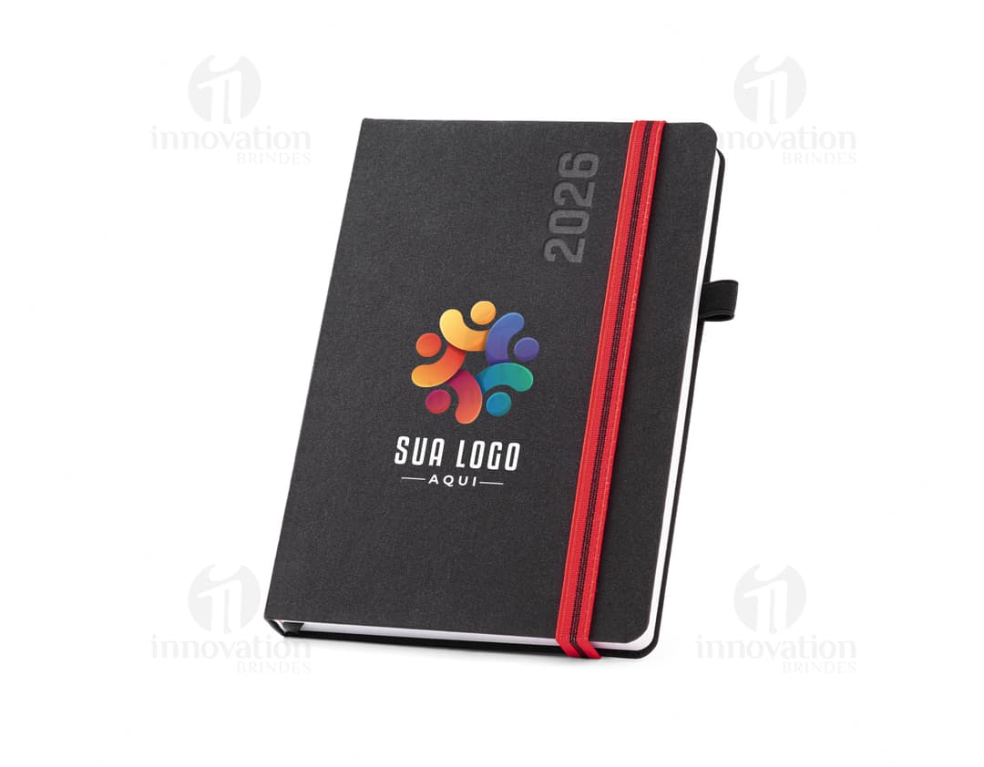 agenda A5 do ano 2026 em destaque em um fundo branco, com capa dura e páginas em branco aberta para visualização.