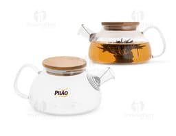Bule de vidro transparente com alças de metal e tampa de plástico preto em fundo branco.