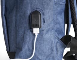 Homem de negócios usando um dispositivo eletrônico em um avião, com uma mochila de nylon preta nas costas. O bolso da mochila