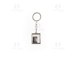 Chaveiro de metal em formato de corrente com chave, amuleto e outros objetos pendurados. Feito em prata e ouro, com design