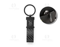 Chaveiro em couro sintético preto com detalhe de metal prateado em forma de coração.