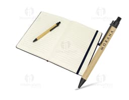 Caderneta de fibra de arroz com caneta em fundo branco. O caderno é marrom claro e possui detalhes em preto na capa. A caneta