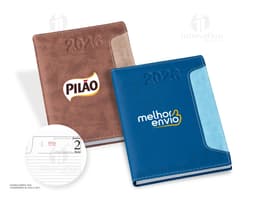 Agenda diária para o ano de 2026, com capa em couro marrom e fecho de elástico preto. Páginas internas em papel branco com
