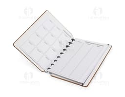 Caderno de disco Percalux marrom com capa de couro, aberto, contendo folhas em branco e um lápis antigo.