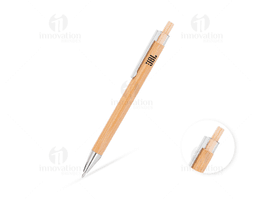 Caneta em bambu sobre um caderno com lápis e papel, em um ambiente de trabalho ou estudo.