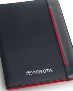Pasta A4 - 09 em couro preto, com espaço para notebook, dispositivos, drive externo, documentos, pen drive, informações, escrita, planejamento e armazenamento. Design moderno e compacto, ideal para ambiente de escritório e negócios.