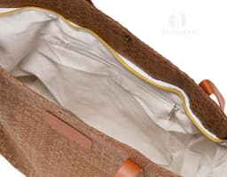 Bolsa de palha trançada marrom, elegante e moderna, com alça de couro, fecho de zíper, detalhes em metal, design vazado, e