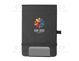 Mini Caderno marrom de couro, aberto, com página em branco. Ao lado, um pen drive, um chaveiro, um diário preto e um celular.
