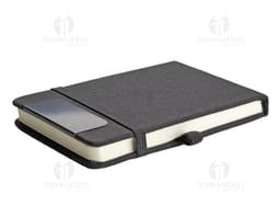 Mini Caderno marrom de couro, aberto, com página em branco. Ao lado, um pen drive, um chaveiro, um diário preto e um celular.