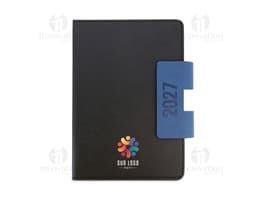 Notebook preto aberto, com teclado e tela exibindo ícones e botões. Ao lado, uma agenda A5 com capa dura em PU, destacando-se