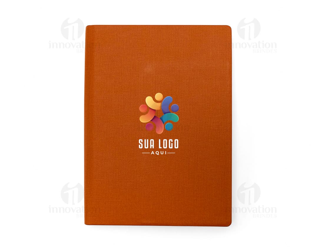 Caderno Fichário PU marrom com capa dura, contendo papel em branco para anotações. Inclui clips para prender folhas, quadro