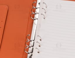 Caderno Fichário PU marrom com capa dura, contendo papel em branco para anotações. Inclui clips para prender folhas, quadro