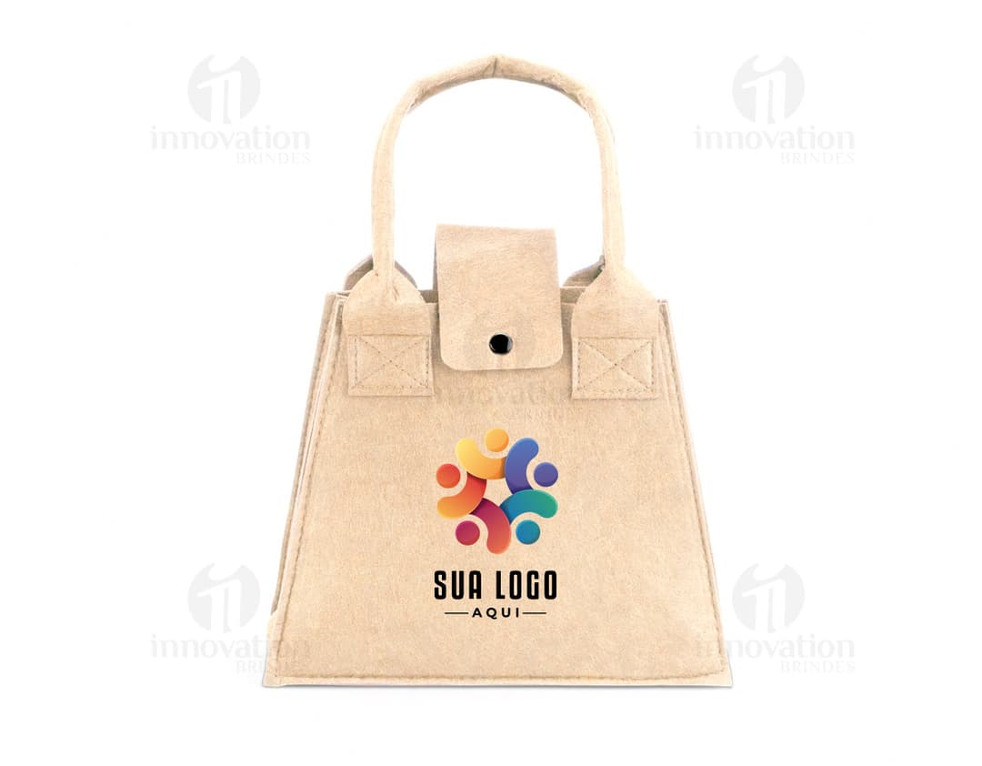 Bolsa de feltro marrom com fecho de metal, alça de couro e detalhes em etiqueta de papel. O produto mostra elegância e