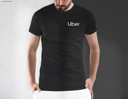 Homem jovem e atraente usando uma camiseta preta tradicional, sorrindo de forma confiante e casual. Ele está em pé, posando