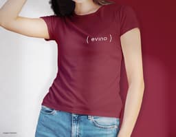 Camiseta feminina de corte cinturado em cor azul, usada por uma modelo sorridente e atraente. Ela está posando de forma