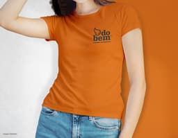 Camiseta feminina de corte cinturado em cor azul, usada por uma modelo sorridente e atraente. Ela está posando de forma