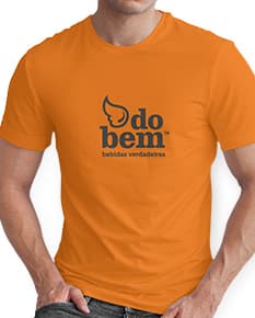 Homem jovem e atraente posando de maneira casual com uma camiseta de algodão tradicional. Ele está sorrindo e tem um sorriso feliz e confiante. O modelo está vestindo jeans e tem um visual moderno e descontraído.