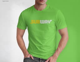 Homem jovem e atraente posando de maneira casual com uma camiseta de algodão tradicional. Ele está sorrindo e tem um sorriso