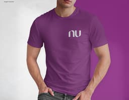 Homem jovem e atraente posando de maneira casual com uma camiseta de algodão tradicional. Ele está sorrindo e tem um sorriso