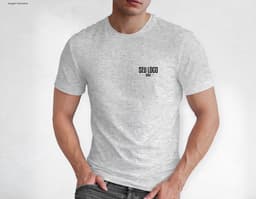 Homem jovem e atraente posando de maneira casual com uma camiseta de algodão tradicional. Ele está sorrindo e tem um sorriso