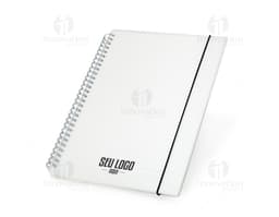 Notebook B5 Plástico 26x19 em fundo branco aberto, com papel em branco e envelope ao lado. Objeto de estudo e organização