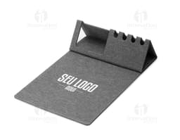 Mouse pad de couro marrom aberto em cima de uma mesa de escritório, ao redor estão um notebook preto, uma bolsa de couro