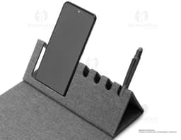 Mouse pad de couro marrom aberto em cima de uma mesa de escritório, ao redor estão um notebook preto, uma bolsa de couro