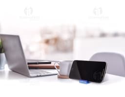 Suporte acrílico para celular em um escritório com computador, notebook, lápis, tela digital e outros equipamentos de