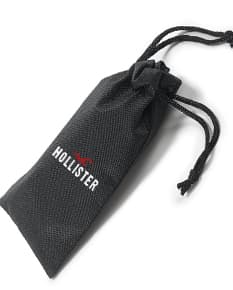 Bolsa para óculos preta de couro, com fecho de cordão e detalhes em metal. Contém etiqueta vazia e etiqueta de preço.