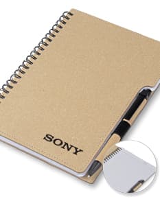 Caderno em couro marrom antigo com páginas em branco, caneta e dinheiro escritos.