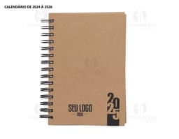 Foto de uma agenda diária para o ano de 2025, com capa marrom e textura de papel antigo. A agenda possui espiral, páginas em