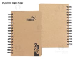 Foto de uma agenda diária para o ano de 2025, com capa marrom e textura de papel antigo. A agenda possui espiral, páginas em