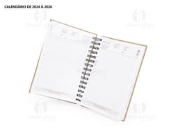Foto de uma agenda diária para o ano de 2025, com capa marrom e textura de papel antigo. A agenda possui espiral, páginas em