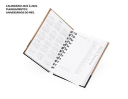 Agenda Diária 2025 com capa dura preta e páginas em papel reciclado, vista de cima em um fundo branco.