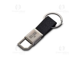 Chaveiro de couro preto com detalhes em metal prateado. Possui um suporte para celular e uma ferramenta cortante embutida. O