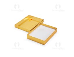 Caixa de presente na cor vermelha, com laço dourado e pequenos detalhes brilhantes.