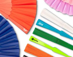 Leque de plástico colorido, com design moderno e brilhante. O leque possui formas geométricas em tons de amarelo, laranja