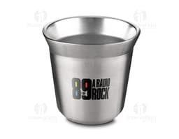 Copo térmico para espresso em cerâmica amarela, com alça e colher de metal, sobre uma mesa.