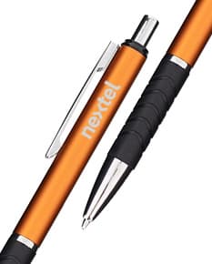 Caneta de metal touch em diversas cores sobre um caderno aberto com diversas ferramentas de escrita e desenho ao redor.